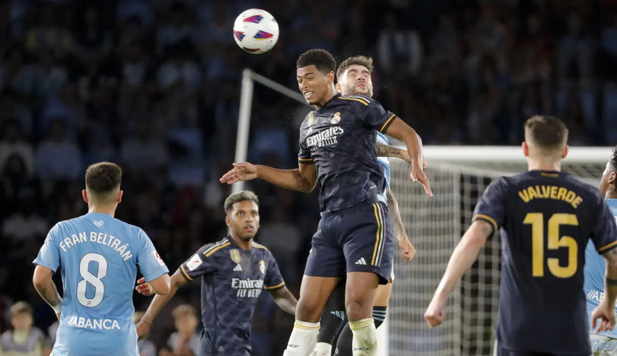 Pemain Real Madrid, Jude Bellingham, duel udara dengan pemain Celta Vigo pada laga Liga Spanyol di Stadion The Balaidos, Sabtu (26/8/2023). Madrid menang dengan skor tipis 1-0. (AP Photo/Lalo R. Villar)