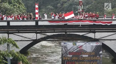 Bendera Merah Putih dikibarkan pada upacara peringatan HUT Kemerdekaan RI di Jembatan Panus, Depok, Kamis (17/8). Komunitas Ciliwung Depok melakukan pengibaran bendera di Jembatan Panus yang melintang di atas Sungai Ciliwung (Liputan6.com/Herman Zakharia)