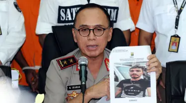 Kapolda Metro Jaya, Irjen Pol M Iriawan menunjukkan foto tersangka kasus kekerasan yang masih buron saat rilis di Jakarta, Kamis (13/7). Polisi menangkap empat orang dan masih memburu satu tersangka lainnya. (Liputan6.com/Helmi Fithriansyah)