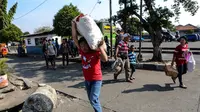 Seorang pemudik mengangkut barangnya usai tiba di Terminal Pulogadung, Jakarta Timur. (Liputan6.com/Faizal Fanani)