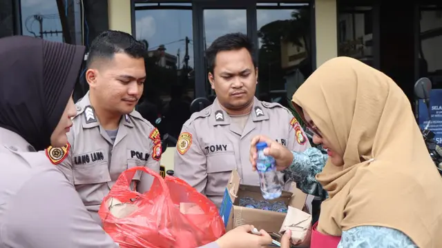 Anggota Polres Metro Depok memberikan makanan dan minuman kepada masyarakat yang meminta pelayanan SKCK di Sat Intelkam Polres Metro Depok. (Liputan6.com/Dicky Agung Prihanto)