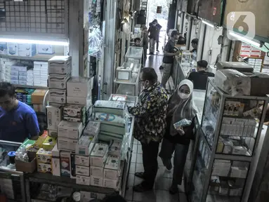 Pedagang melayani pembeli obat-obatan dan perlengkapan medis di Pasar Pramuka, Jakarta Timur, Senin (23/5/2022). Menurut pedagang, penjualan masker di Pasar Pramuka mengalami penurunan mencapai 50 persen meski harga telah normal pasca kebijakan Presiden Joko Widodo atau Jokowi terkait pelonggaran penggunaan masker di ruang terbuka. (merdeka.com/Iqbal S Nugroho)