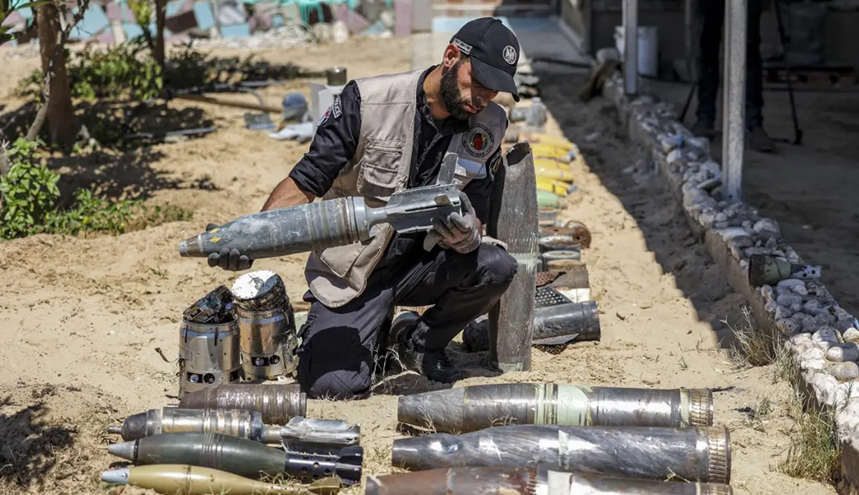 Seorang ahli bahan peledak Hamas menunjukkan proyektil yang tidak meledak setelah konflik Mei 2021 dengan Israel di kantor polisi setempat di Khan Yunis, Jalur Gaza, Sabtu (5/6/2021). Perang 11 hari antara Hamas dan Israel menewaskan 254 orang Palestina dan 12 orang Israel. (MAHMUD HAMS/AFP)