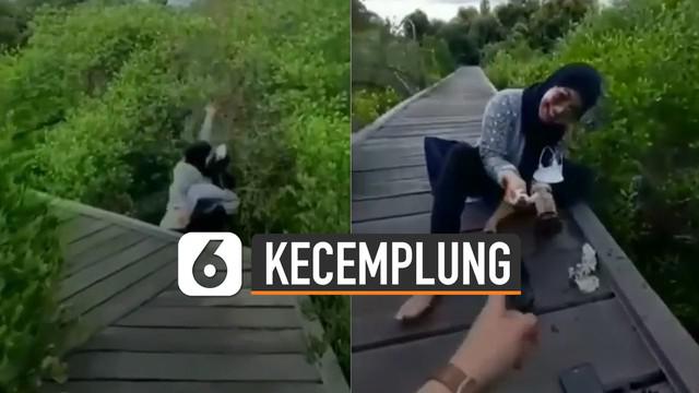 Nasib apes dialami oleh perempuan ini ketika sedang bergaya di sebuah tempat wisata justru jatuh terperosok ke hutan mangrove.
