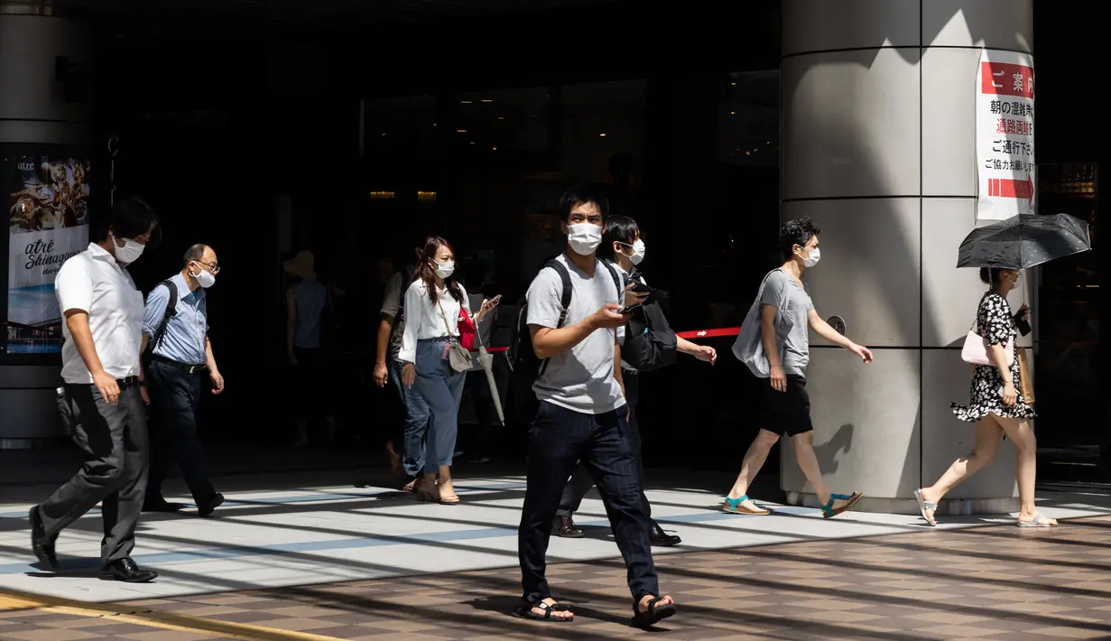 Komuter memakai masker di stasiun kereta api di Tokyo saat keadaan darurat virus corona tetap berlaku di kota itu pada Selasa (10/8/2021).  Pemerintah Metropolitan Tokyo mengonfirmasi 2.884 kasus baru covid-19 pada Senin, 9 Agustus 2021. (Yuki IWAMURA / AFP)