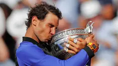 Petenis Spanyol, Rafael Nadal mencium trofinya setelah mengalahkan Stan Wawrinka pada final Prancis Terbuka di Roland Garros, Minggu (11/6). Nadal unggul dengan skor 6-2, 6-3, 6-1 untuk meraih gelar kesepuluh atau La Decima. (AP Photo/Christophe Ena)