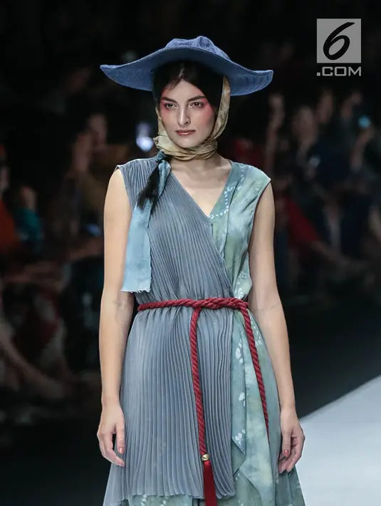Model memperagakan busana rancangan HUMBANG SHIBORI x PURANA saat Jakarta Fashion Week 2019 di Senayan City, Jakarta, Kamis (25/10). Tenun ikat Humbang Shibori merupakan kerajinan kriya yang dibuat dengan metode ikat celup. (Liputan6.com/Faizal Fanani)