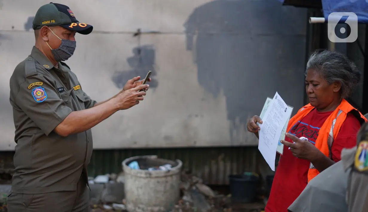 Petugas Satpol PP memfoto warga yang tidak menggunakan masker di kawasan Pasar Baru, Jakarta, Jumat (21/8/2020). Sanksi tersebut dilakukan sebagai bagian dari upaya pencehagan penyebaran virus covid-19. (Liputan6.com/Immanuel Antonius)