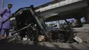 Seorang anak laki-laki berdiri di dekat sepeda motor yang terbakar di pinggir jalan sehari setelah protes keras oleh mantan pendukung Perdana Menteri Pakistan Imran Khan menyusul penangkapannya, di Peshawar, Pakistan, Rabu (10/5/2023). (AP Photo/Muhammad Sajjad)
