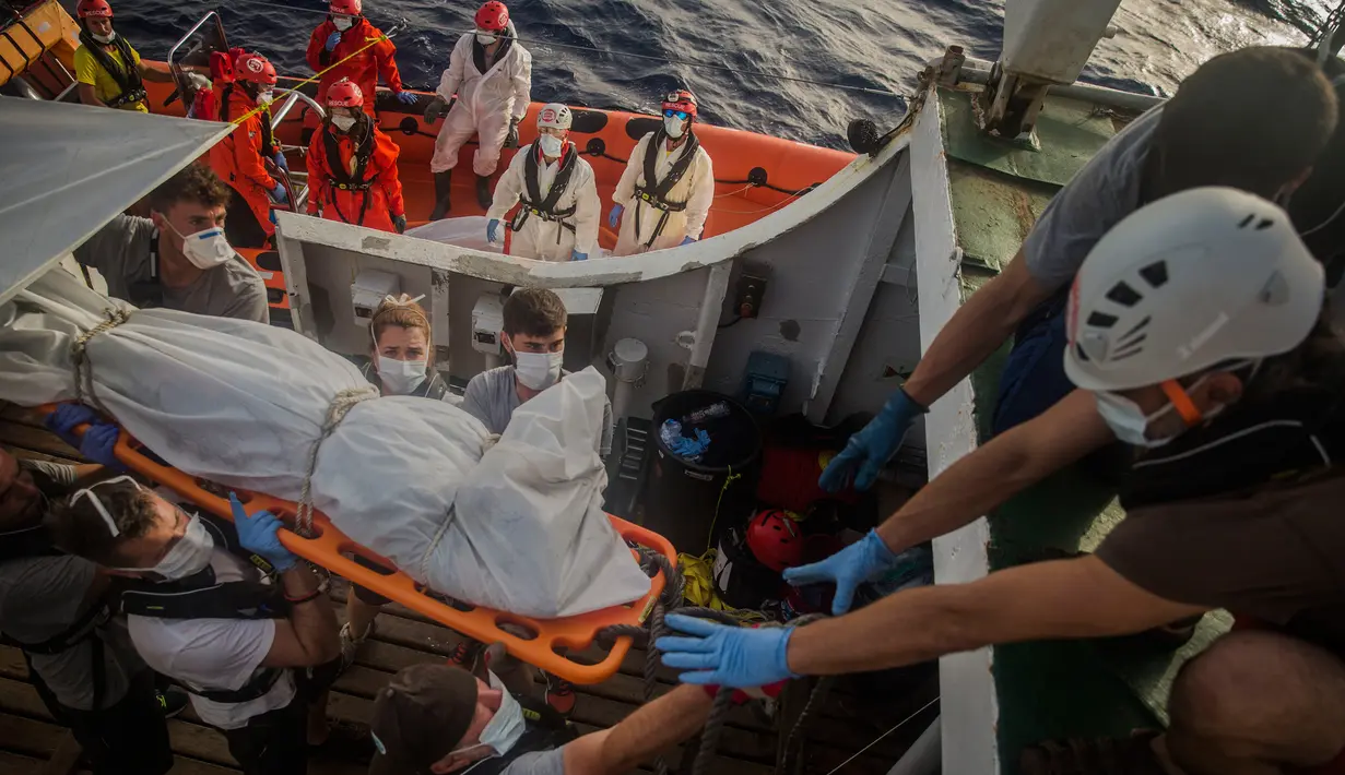 Petugas LSM Spanyol mengevakuasi jasad imigran Afrika sub-Sahara di tengah Laut Mediterania, lepas pantai Libya, Selasa (25/7). Dalam operasi penyelamatan, petugas menemukan 13 jasad di atas perahu karet yang membawa 160 orang migran. (AP/Santi Palacios)