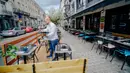 Seorang pelayan menyiapkan meja di sebuah restoran di Brussel, Belgia, Selasa  (7/7/2020). Komisi Eropa memprediksi Ekonomi Eropa akan menghadapi resesi lebih dalam akibat langkah-langkah pengendalian COVID-19 yang berkepanjangan. (Xinhua/Zhang Cheng)