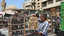 Seorang pria Irak membawa burung di dalam sangkar burung di pasar hewan peliharaan al-Ghazal di ibukota Irak, Baghdad (11/10/2019). Pasar hewan peliharaan yang berada di kota Baghdad ini telah ada sejak tahun 1950-an. (AFP Photo/Ahmad Al-Rubaye)