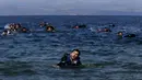 Seorang pengungsi Suriah tampak kelelahan saat berenang menuju pantai setelah perahu yang ditumpangi bocor sekitar 100 m sebelum mencapai pulau Lesbon, Yunani, Minggu (13/09/2015). (REUTERS/Alkis Konstantinidis)