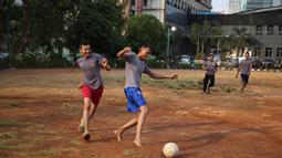Polisi dari kesatuan Sabhara merenggangkan otot dengan bermain bola di Kawasan Polda Metro, Jakarta, Selasa (13/10/2015). Pihak Kepolisian dan TNI bersiap siaga menjelang laga Final Piala Presiden 2015. (Bola.com/Nicklas Hanoatubun).
