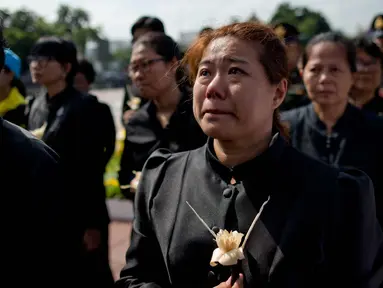 Warga Thailand menangis saat menghadiri upacara kremasi mendiang Raja Bhumibol Adulyadej di Bangkok, Thailand, Kamis, (26/10). Upacara pemakaman sendiri akan berlangsung selama lima hari mulai Kamis, 26 Oktober 2017. (AP Photo / Gemunu Amarasinghe)