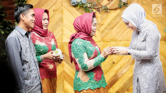 Ibunda  anggota DPRD Sidrap, Idham Masse memasangkan cincin ke jari aktris Shinta Bachir pada prosesi lamaran di Jakarta, Sabtu (8/9). Shinta Bachir resmi dilamar oleh Idham yang juga merupakan politikus Partai Golkar tersebut (Liputan6.com/Faizal Fanani)