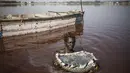 Toure, pemanen garam Gambia, memegang keranjang berisi garam yang dikumpulkan dari kerak dasar Danau Retba di Senegal pada 16 Maret 2021. Danau Retba, atau dalam bahasa lokal disebut Lac Rose hanya dipisahkan oleh sejumlah bukit bercelah sempit dari Samudera Atlantik. (MARCO LONGARI/AFP)