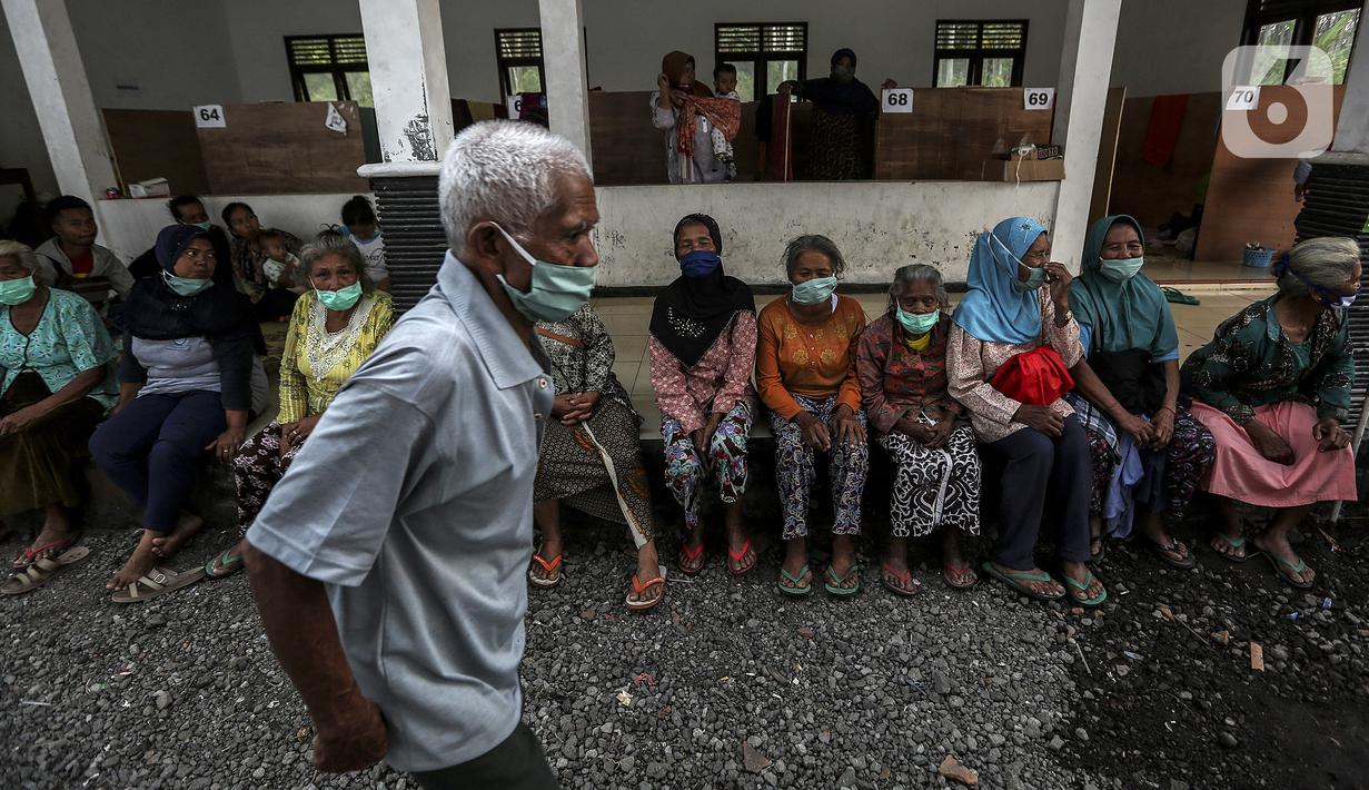 Pengungsi Gunung Merapi mengenakan masker di lokasi pengungsian di Desa Glagaharjo, Sleman, Jawa Tengah, Rabu (18/11/2020). Kondisi Gunung Merapi yang memasuki level siaga membuat beberapa desa dengan radius 5 Km dari puncak Gunung Merapi mengungsikan penduduknya. (Liputan6.com/Johan Tallo)
