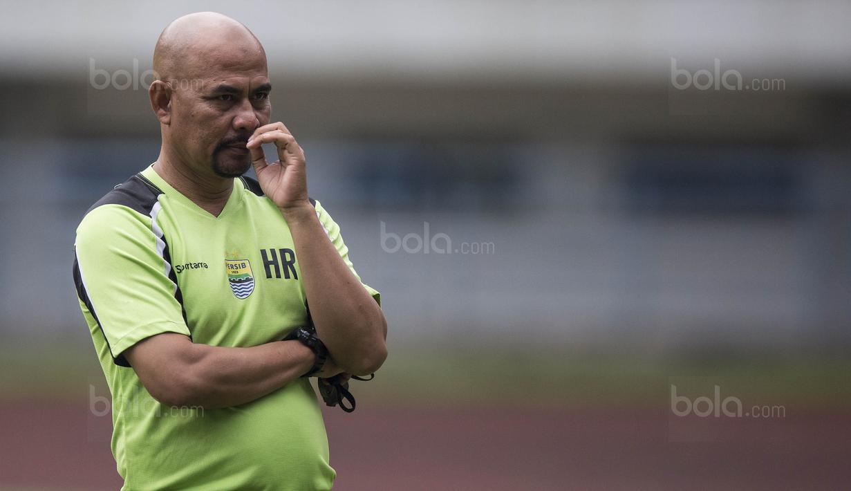 2. Caretaker Persib, Herrie Setiawan, asyik memainkan kumis saat mengamati anak asuhnya berlatih. (Bola.com/Vitalis Yogi Trisna)