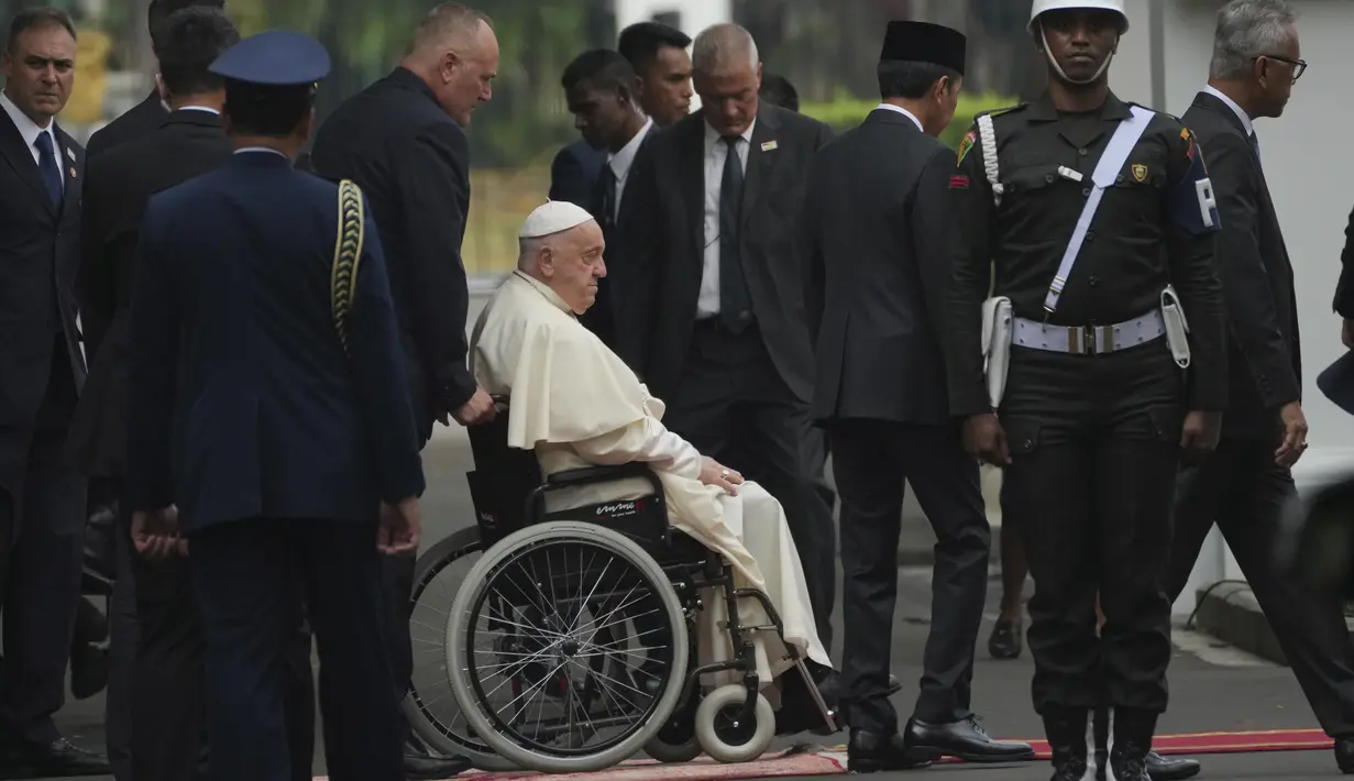 Begitu tiba di sisi kanan Istana Merdeka, Sri Paus yang menggunakan kursi roda disambut langsung oleh Presiden Jokowi. (AP Photo/Achmad Ibrahim, Pool)