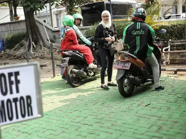 Ojek online menurunkan penumpang di tempat drop off yang disediakan di Balai Kota DKI Jakarta, Selasa (31/7). Pemprov DKI menginstruksikan adanya tempat pemberhentian khusus bagi ojek online di kantor-kantor Pemprov DKI. (Liputan.com/Faizal Fanani)