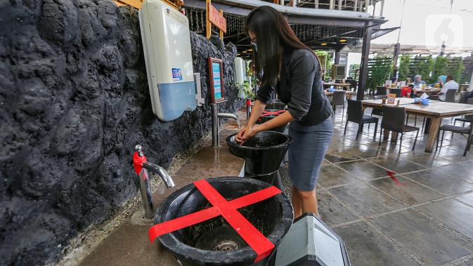 Konsumen mencuci tangan di wastafel yang ditempel stiker physical disatancing di Restoran Bandar Djakarta, Alam Sutera, Tangerang Selatan, Rabu (10/6/2020). Meski PSBB Tangerang Raya diperpanjang dan masuk kategori zona kuning restoran tetap menerapkan protokol kesehatan. (Liputan6.com/Fery Pradolo)