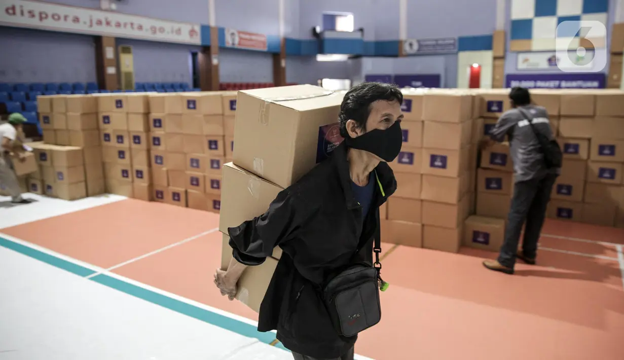 Relawan Gugus Tugas Percepatan Penanganan COVID-19 memindahkan kotak berisi sembako di GOR Gelanggang Remaja, Jakarta, Senin (18/5/2020). Relawan Gugus Tugas Percepatan Penanganan COVID-19 membagikan 30.000 paket bantuan kepada warga Jabodetabek yang terdampak COVID-19. (Liputan6.om/Faizal Fanani)