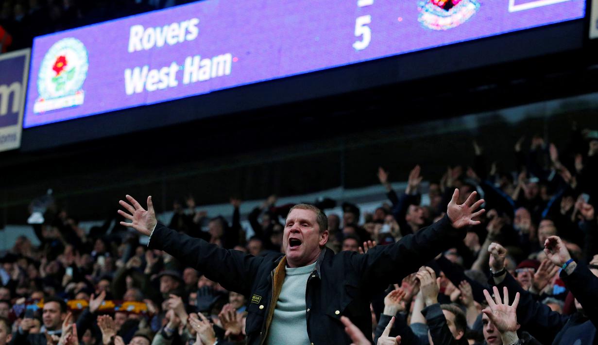 Suporter West Ham United merayakan kemenangan atas Blackburn Rovers dalam putaran kelima Piala FA di Stadion Ewood Park, Blackburn, (21/2/2016). (AFP/Lindsey Parnaby)