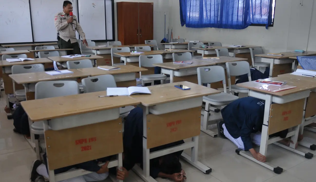 Petugas melakukan sosialisasi dan simulasi gempa bumi di Sekolah SMPN 198, Jakarta, Selasa (26/9/2023). (merdeka.com/Imam Buhori)