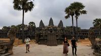 Sejumlah wisatawan berjalan di Candi Angkor Wat, Provinsi Siem Reap, Kamboja, Kamis (5/3/2020). Menurut World Travel and Tourism Council, wabah virus corona (COVID-19) membuat sektor pariwisata dunia kehilangan USD 22 miliar. (TANG CHHIN Sothy/AFP)