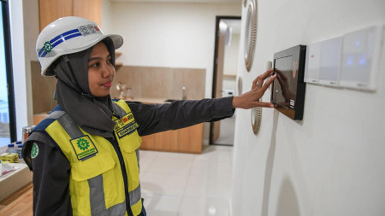 Pekerja mencoba alat pengatur rumah pintar (smart home control) di unit Rusun ASN di IKN