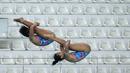 Atlet loncat indah putri Jawa Timur, Gladies Lariesa Garina (kiri) dan Linar Betiliana beraksi pada nomor menara synchro putri Kejurnas Akuatik 2026 yang berlangsung di Stadion Akuatik Gelora Bung Karno, Senayan, Jakarta. (Bola.com/Bagaskara Lazuardi)