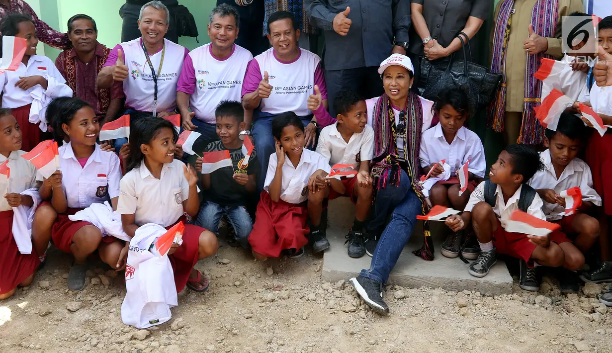 Menteri BUMN Rini Soemarno bersama Direktur ASABRI Sonny Widjaja foto bersama siswa SD saat meninjau program bantuan bedah rumah bagi mantan pejuang pro integrasi Timor  Timur di Desa Oebelo, Kupang, NTT, Selasa (14/8). (Liputan6.com/JohanTallo)