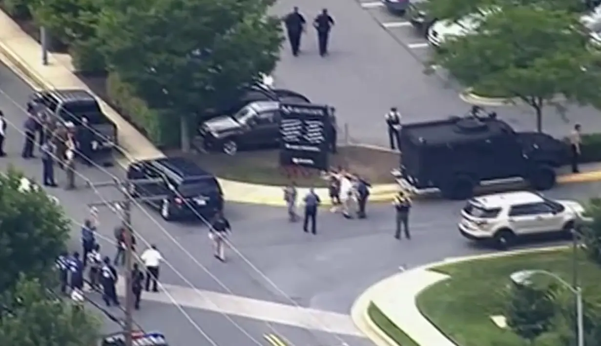 Foto dari rekaman video, orang-orang meninggalkan kantor surat kabar Capital Gazette setelah terjadi penembakan di Annapolis, AS, Kamis (28/6). Polisi meyakini pelaku yang merupakan pria kulit putih berusia 20-an itu bertindak sendiri. (WJLA via AP)
