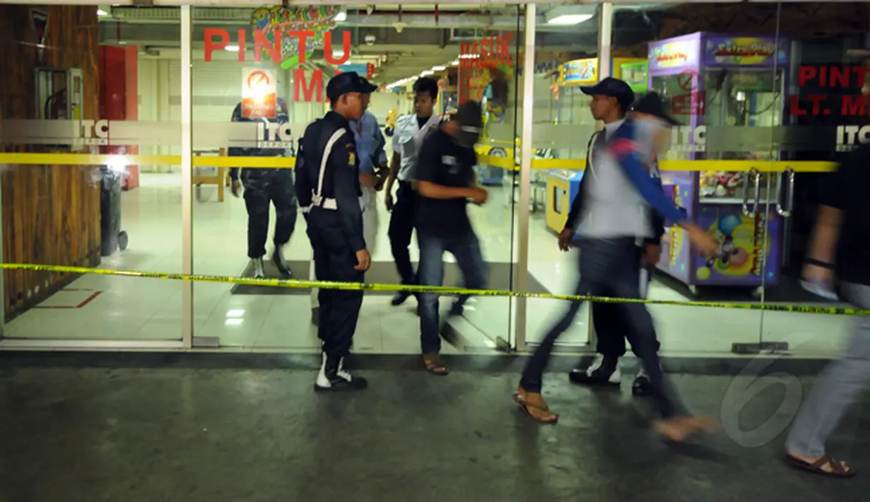Beberapa orang keluar dari dalam Mall ITC TC Depok, Jawa Barat, Selasa dini hari (24/2/2015). Sebuah ledakan kecil terjadi di Mall ITC Depok pada Senin (23/2/2015). (Liputan6.com/Helmi Fithriansyah)