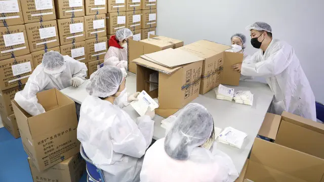 Pekerja mengemas masker kesehatan N95 di area aseptik sebuah perusahaan produsen masker di Shenyang, China, 8 Februari 2020.