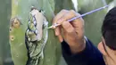 Seniman muda Palestina, Ahmad Yasin saat melukis tanaman kaktus di desa Tepi Barat Aseera Ashmaliya dekat Nablus, (31/3). Berbagai gambar unik dituangkan Ahmad Yasin kedalalam sejumlah tangkai kaktus.  (REUTERS / Abed Omar Qusini)
