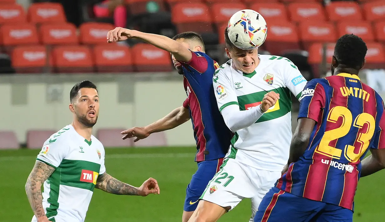 Striker Elche, Guido Carrillo (kedua dari kanan) melepaskan sundulan di mulut gawang Barcelona dalam laga lanjutan Liga Spanyol 2020/21 pekan ke-24 di Camp Nou Stadium, Barcelona, Rabu (24/2/2021). Elche kalah 0-3 dari Barcelona. (AFP/Lluis Gene)