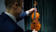 Perwakilan dari Sotheby Hong Kong memegang biola langka 1684 buatan Antonio Stradivari saat diperkenalkan di hadapan pers di Hong Kong (21/2). Pelelangan biola ini akan digelar pada 28 Maret 2017 mendatang di London. (AFP Photo / Isaac Lawrence)