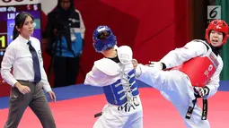 Atlet taekwondo putri Indonesia, Fitriyana Yusuf melayangkan tendangannya ke arah Liu Qing dari Makau pada babak 16 besar di Jakarta Convention Center (JCC), Senin (20/8). Fitriyana kalah tipis 21 - 25 pada kelas Wanita 67 kg. (Liputan6.com/Fery Pradolo)