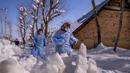 Fozia (kanan) dan Tasleema, petugas kesehatan Kashmir, membawa vaksin saat mereka berjalan di jalan yang tertutup salju selama upaya vaksinasi COVID-19 di Budgam, barat daya Srinagar, Kashmir yang dikuasai India, pada 11 Januari 2022. (AP Photo/Dar Yasin)