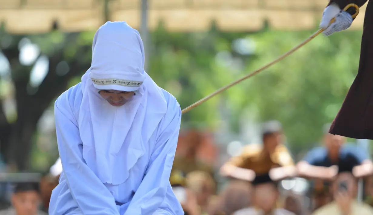 Seorang karyawati bernama Nur Fadilah (21) mendapat hukum cambuk karena mesum di Banda Aceh, Senin (29/10). Nur mendapat hukuman sebanyak 23 cambukan. (Chaideer Mahyuddin/AFP)