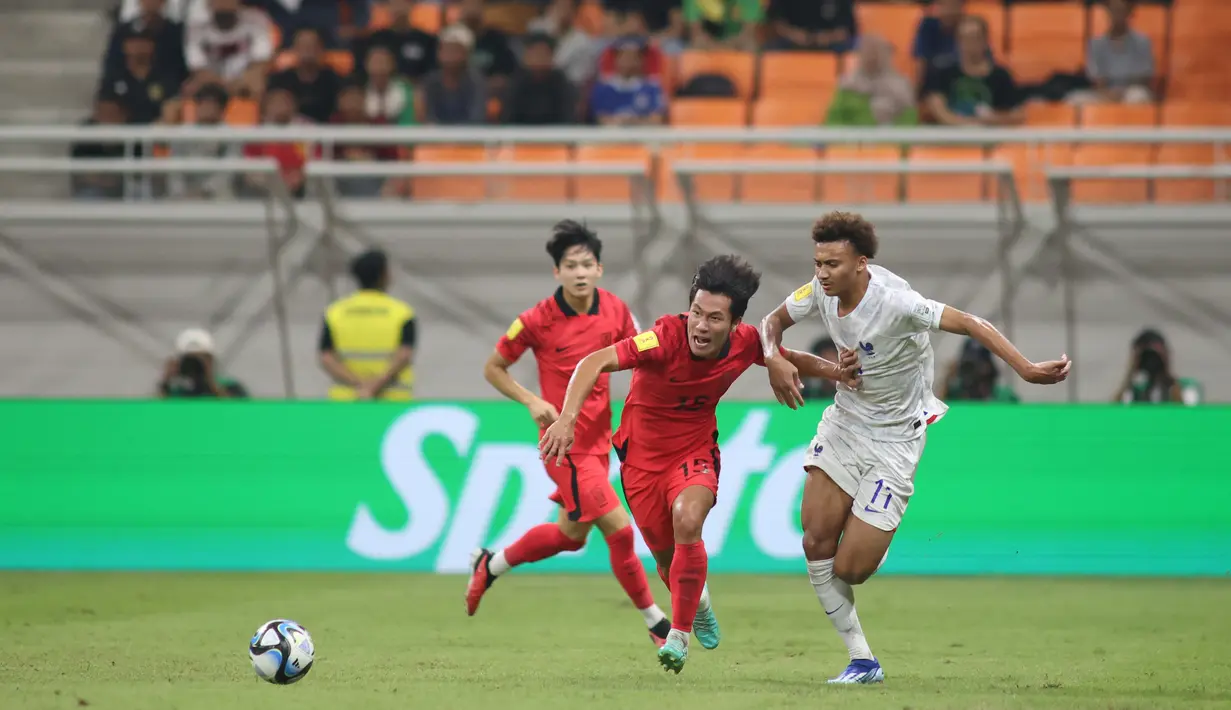 Pemain timnas Korea Selatan U-17 Jeonghyeok Seo berebut bola dengan timnas Prancis U-17 Tidiam Gomis pada persaingan Grup E Piala Dunia U-17 2023 di Jakarta International Stadium, Rabu (15/11/2023). (Doc. LOC WCU17/BRY)