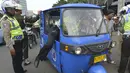 Polisi berusaha mengendarai bajaj yang terkena razia ketika digelar Operasi Zebra 2014 di sekitar Pasar Senen, Jakarta, Rabu (26/11). (ANTARA FOTO/Saptono)