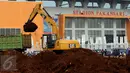 Alat berat melakukan proses pengerukan tanah di luar Stadion Pakansari, Kabupaten Bogor, Minggu (21/8). Jelang pelaksanaan PON XIX Jawa Barat, pembangunan sarana pertandingan di Stadion Pakansari terus dikerjakan. (Liputan6.com/Helmi Fithriansyah)