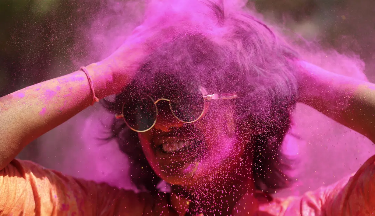 Orang yang bersuka ria diolesi bedak berwarna di wajah orang lain selama perayaan menandai Holi, festival warna Hindu, di Mumbai, India (18/3/2022).  Holi, festival warna Hindu, juga menandai datangnya musim semi. (AP Photo/Mahesh Kumar A.)