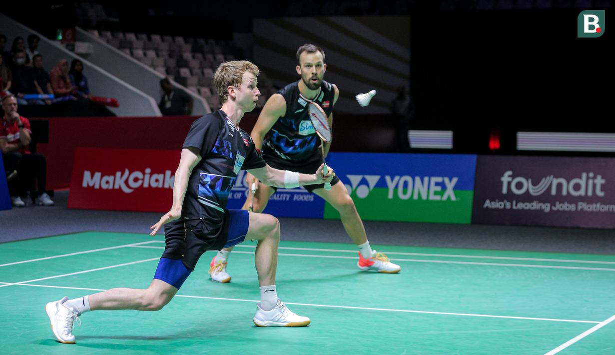 Pebulu tangkis ganda putra Denmark, Kim Astrup/Anders Skaarup Rasmussen mengembalikan kok ke arah pasangan Indonesia, Bagas Maulana/Muhammad Shohibul Fikri pada babak perempat final Indonesia Open 2024 di Istora Senayan, Jakarta, Jumat (07/06/2024). (Bola.com/Bagaskara Lazuardi)