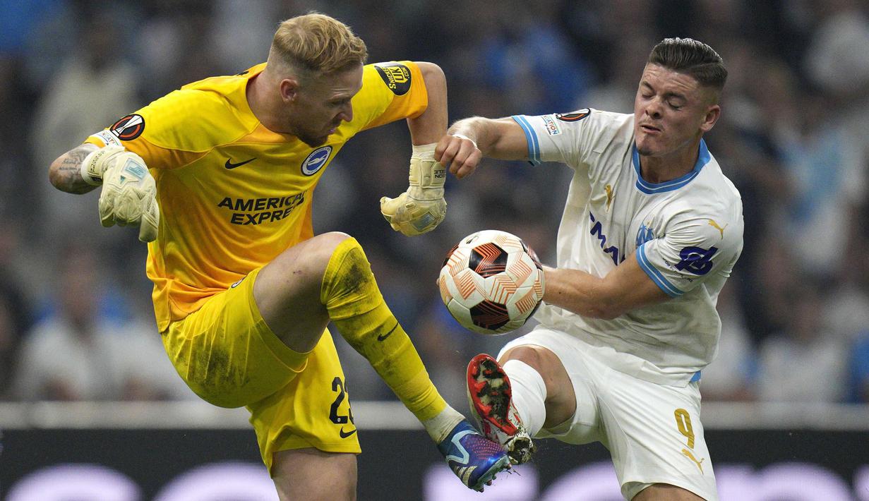 Kiper Brigthon, Jason Steele (kiri) berebut bola dengan pemain Marseille, Vitor Oliveira Vitinha pada laga Grup B Liga Europa 2023/2024 di Stade Velodrome, Marseille, Prancis, Jumat (05/10/2023) dini hari WIB. (AP Photo/Daniel Cole)