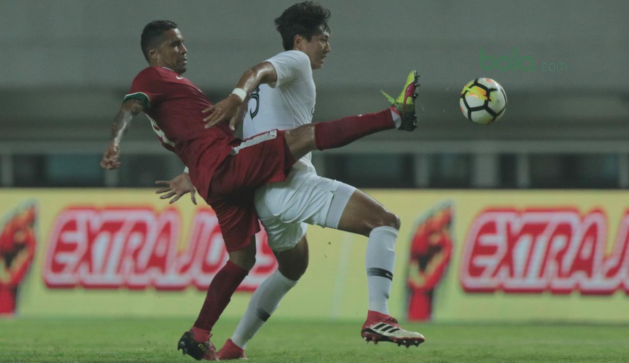 Pemain Timnas Indonesia, Alberto Goncalves (kiri) menghalau bola dari pemain Korea Selatan U-23 pada laga uji coba di Stadion Pakansari, Bogor, (23/6/2018).  Indonesia U-23 kalah 1-2 dari Korea U-23. (Bola.com/Nick Hanoatubun)