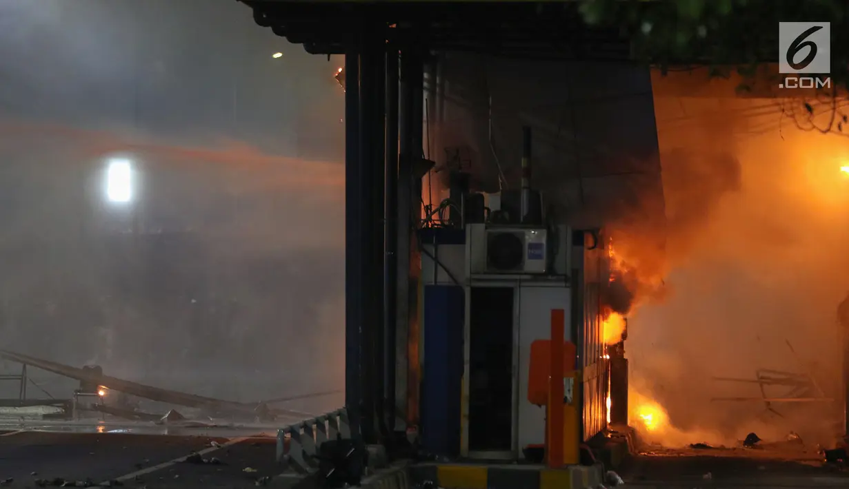 Gardu Tol Pejompongan 1 dibakar massa saat demonstrasi mahasiswa di depan Gedung DPR/MPR, Jakarta, Selasa (24/9/2019). PT Jasa Marga menutup jalan Tol Dalam Kota Cawang-Tomang guna menjaga keselamatan dan keamanan pengguna jalan. (Liputan6.com/Johan Tallo)